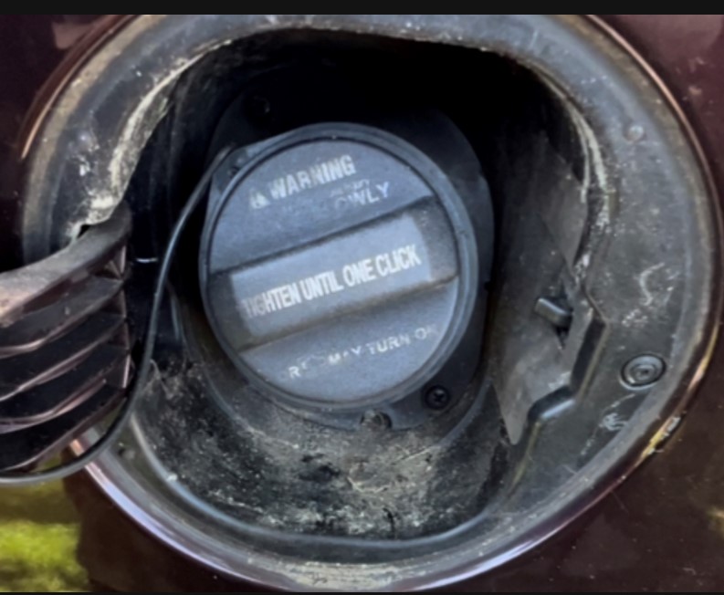 Close-up of a mechanic fixing a fuel door mechanism